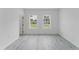 Bright bedroom featuring two windows and light gray flooring at 741 Marion Oaks Ln, Ocala, FL 34473