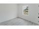 Minimalist bedroom featuring a window, light gray floors, and white walls, creating a serene and inviting space at 741 Marion Oaks Ln, Ocala, FL 34473