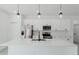 Modern kitchen featuring white cabinetry, stainless appliances, and stylish pendant lighting above a spacious island at 741 Marion Oaks Ln, Ocala, FL 34473