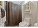 Cozy bathroom featuring a black and white checked shower curtain, matching towel, and storage cabinet at 789 Errol Pkwy, Apopka, FL 32712