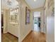 Inviting hallway featuring hardwood floors leading to a bathroom and living area with abundant natural light at 789 Errol Pkwy, Apopka, FL 32712