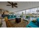 This covered patio offers an in-ground pool, comfortable seating, a ceiling fan, and nice water views at 789 Errol Pkwy, Apopka, FL 32712