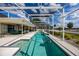 Long, screened-in pool featuring a hot tub with serene landscaping and a spacious patio at 789 Errol Pkwy, Apopka, FL 32712