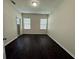 Bright bedroom with dark wood floors and two windows at 8271 Maritime Flag St # 125, Windermere, FL 34786