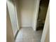 Hallway leading to a bathroom and outside access, featuring neutral tile flooring at 8271 Maritime Flag St # 125, Windermere, FL 34786