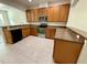 A kitchen showcasing stainless steel appliances, wood cabinets, and expansive countertop space at 8271 Maritime Flag St # 125, Windermere, FL 34786