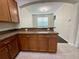 Well-lit kitchen featuring granite countertops, wooden cabinets, and stainless steel hardware at 8271 Maritime Flag St # 125, Windermere, FL 34786