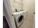 A well-equipped laundry room with a front-load washer, dryer, and wire shelving for storage at 8271 Maritime Flag St # 125, Windermere, FL 34786