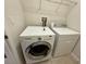 A well-equipped laundry room with a front-load washer, dryer, and wire shelving for storage at 8271 Maritime Flag St # 125, Windermere, FL 34786