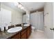 Bathroom with double sinks, granite countertop and a shower with patterned curtain at 918 Emerald Green Ct, Kissimmee, FL 34746