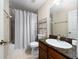 Well-lit bathroom featuring a granite vanity top and a shower with tiled surround and decorative curtain at 918 Emerald Green Ct, Kissimmee, FL 34746
