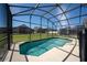 Sparkling pool with a screened-in enclosure and well-maintained lawn at 918 Emerald Green Ct, Kissimmee, FL 34746