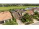 Aerial shot of a home with a tile roof, solar panels, a screened in lanai, and beautiful golf course views at 9895 Winnington St, Orlando, FL 32832