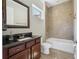 Bathroom featuring tiled shower and wood vanity with dark countertop at 9895 Winnington St, Orlando, FL 32832