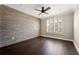 Bedroom features an accent wall, ceiling fan, and dark wood floors at 9895 Winnington St, Orlando, FL 32832
