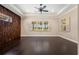 Spacious bedroom features dark wood floors, a tray ceiling, and a unique wood accent wall for added character at 9895 Winnington St, Orlando, FL 32832