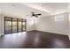 Bright bonus room with dark floors, ceiling fan, recessed lighting, and access to balcony at 9895 Winnington St, Orlando, FL 32832
