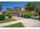 A beautiful home boasting a manicured lawn, two-car garage, brick driveway, and lush landscaping at 9895 Winnington St, Orlando, FL 32832