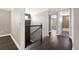 Hallway with elegant dark wood floors, staircase with wrought iron railing and chandelier at 9895 Winnington St, Orlando, FL 32832