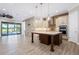 Gourmet kitchen featuring pendant lighting, stone accent wall, white cabinetry, and a large island perfect for entertaining at 9895 Winnington St, Orlando, FL 32832