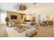 Bright, open-concept living room featuring wood floors, brick accent wall, and modern furnishings adjacent to gourmet kitchen at 9895 Winnington St, Orlando, FL 32832