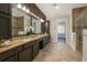 Bathroom features granite countertops with dual sinks, dark wood cabinets and hardware, and a glass-enclosed shower at 9895 Winnington St, Orlando, FL 32832