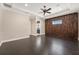 The primary bedroom includes dark hardwood floors, a ceiling fan, and a wood accent wall with a passthrough window at 9895 Winnington St, Orlando, FL 32832