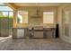 Covered outdoor kitchen with built-in grill, mini fridge, sink, and stone accents at 9895 Winnington St, Orlando, FL 32832