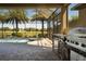 Outdoor kitchen and BBQ area overlooking the screened-in pool, spa, and golf course at 9895 Winnington St, Orlando, FL 32832