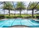 Gorgeous screened-in pool and spa overlooking the green golf course, enhanced by mature palm trees at 9895 Winnington St, Orlando, FL 32832