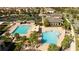 Aerial view of community swimming pools featuring palm trees, covered seating, and a splash pad at 9895 Winnington St, Orlando, FL 32832