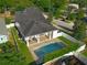 Gorgeous aerial view showcasing a home with a pool, patio, well-maintained lawn, and surrounding greenery at 1114 Georgia Blvd, Orlando, FL 32803