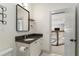 Well-lit bathroom featuring granite counters, a decorative mirror, and an open view to the stairs at 1114 Georgia Blvd, Orlando, FL 32803