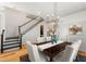 Dining room featuring a wooden table, tufted chairs, and stairs with a dark wood handrail at 1114 Georgia Blvd, Orlando, FL 32803