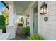 Inviting front porch with brick flooring, white pillars, and a vibrant green front door at 1114 Georgia Blvd, Orlando, FL 32803