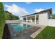 A luxurious pool with a patio and clear blue water, surrounded by manicured landscaping and a white fence at 1114 Georgia Blvd, Orlando, FL 32803