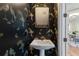 Stylish powder room featuring a pedestal sink and unique bird-themed wallpaper at 1114 Georgia Blvd, Orlando, FL 32803