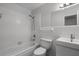 Clean, all-white bathroom featuring a shower-tub combo, toilet, and vanity with modern fixtures at 117 Exeter Ave, Longwood, FL 32750