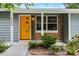Close-up of the stylish front door, showing off its unique design and attractive brick and siding accents at 117 Exeter Ave, Longwood, FL 32750