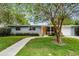 Charming single-story home featuring a well-manicured lawn, inviting walkway, and bright orange front door at 117 Exeter Ave, Longwood, FL 32750