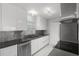 Modern kitchen with sleek white cabinetry, stainless steel appliances, and updated countertops at 117 Exeter Ave, Longwood, FL 32750