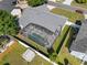 Aerial view of a home with a fenced yard, screened pool, mature trees, and a shed at 118 White Birch Dr, Kissimmee, FL 34743