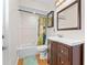Well-lit bathroom with a modern sink and vanity, framed mirror, and shower with tub combination at 118 White Birch Dr, Kissimmee, FL 34743