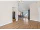 Open-concept dining area with hardwood floors, a chandelier, and views of the front yard through large windows at 118 White Birch Dr, Kissimmee, FL 34743
