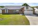 Charming single-story brick home with a well-manicured lawn, attached garage, and welcoming front entrance at 118 White Birch Dr, Kissimmee, FL 34743