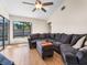Cozy living room featuring a plush sectional sofa, hardwood floors, a ceiling fan, and natural light at 118 White Birch Dr, Kissimmee, FL 34743