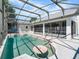 Inviting screened-in pool area with a sparkling pool, concrete deck, and covered patio, perfect for outdoor entertaining at 118 White Birch Dr, Kissimmee, FL 34743