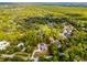 Aerial view of the property showcasing the home's layout, wooded surroundings, and defined property lines at 1201 Groveland Dr, Chuluota, FL 32766