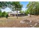 Spacious backyard with mature trees, screened patio, and a fire pit area, offering privacy and relaxation at 1201 Groveland Dr, Chuluota, FL 32766