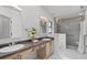 Bathroom featuring a dual-sink vanity, a walk-in shower, and bright lighting at 1201 Groveland Dr, Chuluota, FL 32766